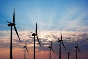 Wind turbines stretching into the horizon at sunset.