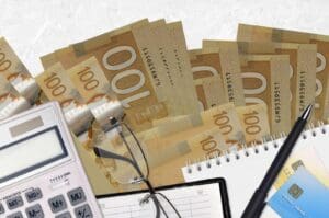 Tax calculations with Canadian cash and calculator.